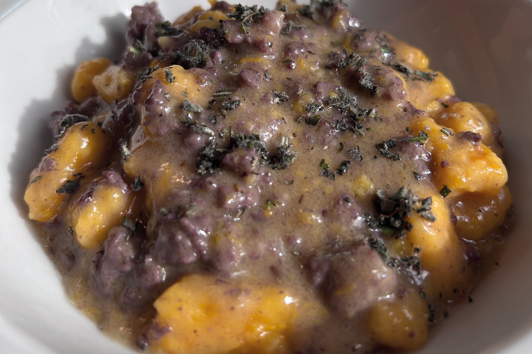 Gnocchi di zucca con pasta di salsiccia al Lambrusco